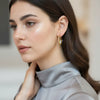 Raya gold plated hoop earrings featuring an enamel evil eye charm motif worn by a model by Eda Jewels Dubai.