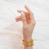 Veya gold plated coiled gaspipe wrap bracelet worn on a model's wrist. Perfect statement daily wear piece by Eda Jewels.